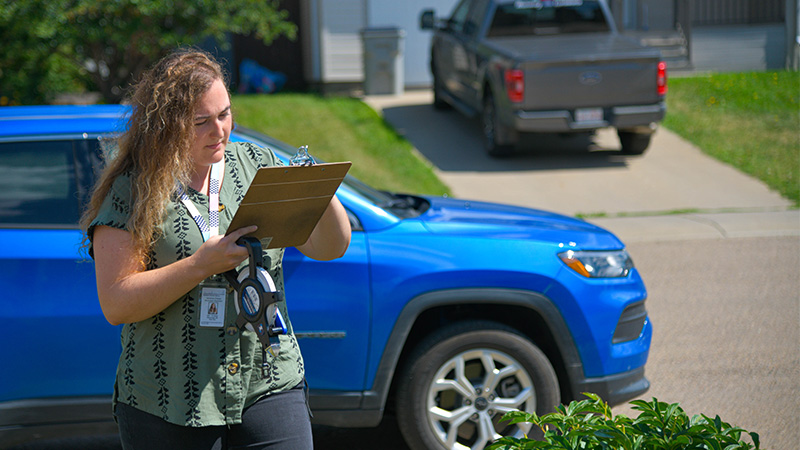 Vanessa Creasy, REAA grad, working outside of a house