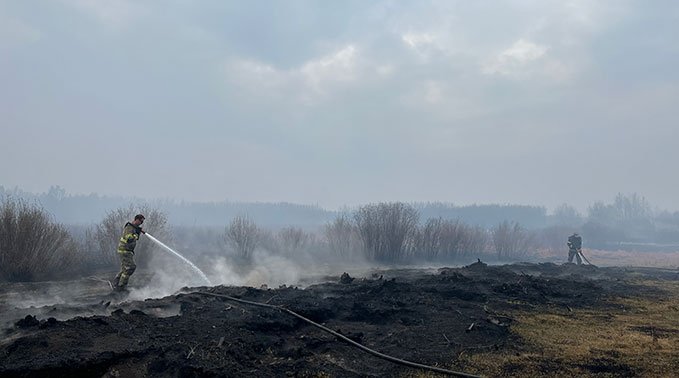 Students spraying water onto site of fire
