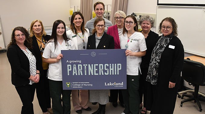 Lakeland College leadership and students hold a sign that says 'A growing partnership' in celebration of a new agreement with University of Saskatchewan.