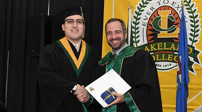 Adam Waterman, Lakeland College Board of Governor's chair, presents Dominic Skibba, who graduated from Lakeland's business administration diploma accounting major, the 2023 Governor General's Academic Medal for the Lloydminster campus. 