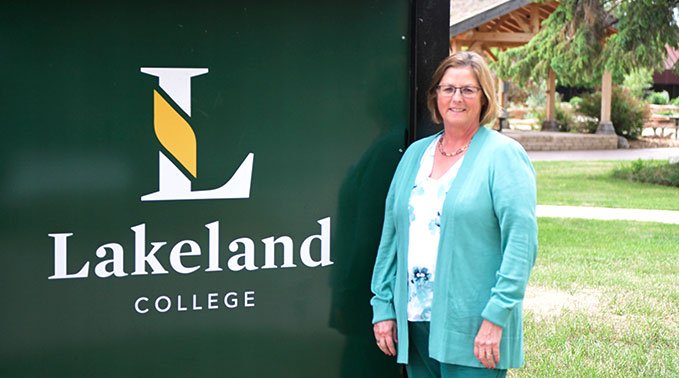 Barb Shackel-Hardman stands in front of a sign with Lakeland College's logo at the College's Vermilion campus.