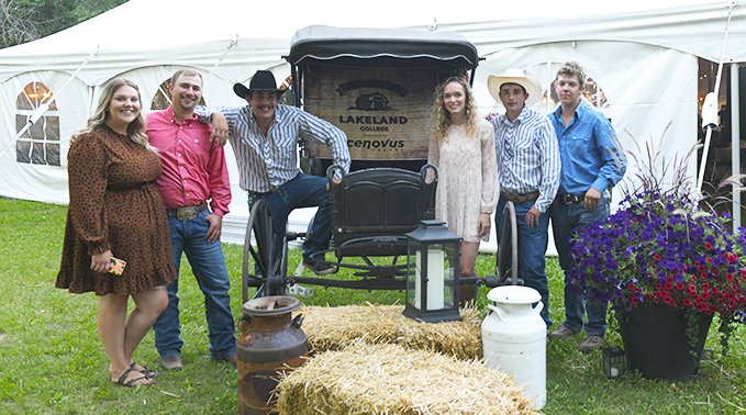 A group of student group together in front of the 2022 Feast on the Farm welcome sign.