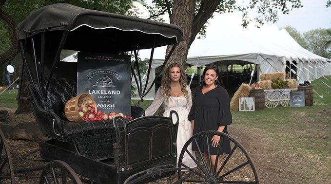 Two students stand at the 2023 Feast on the Farm welcome sign