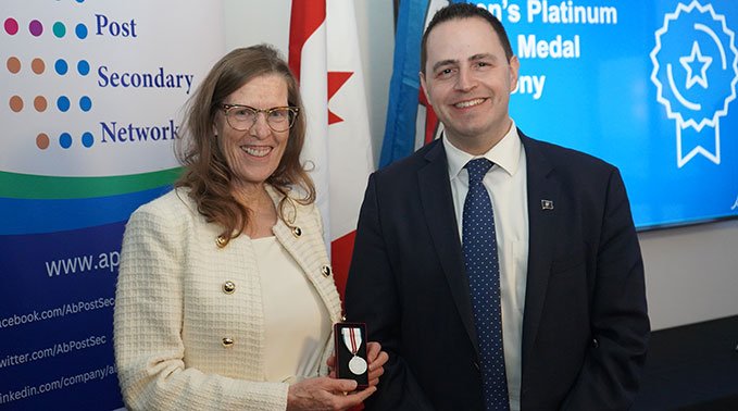 Dr. Alice Wainwright-Stewart (left) receives Queen Elizabeth II's Platinum Jubilee Medal from Demetrios Nicolaides, Alberta minister for advanced education.