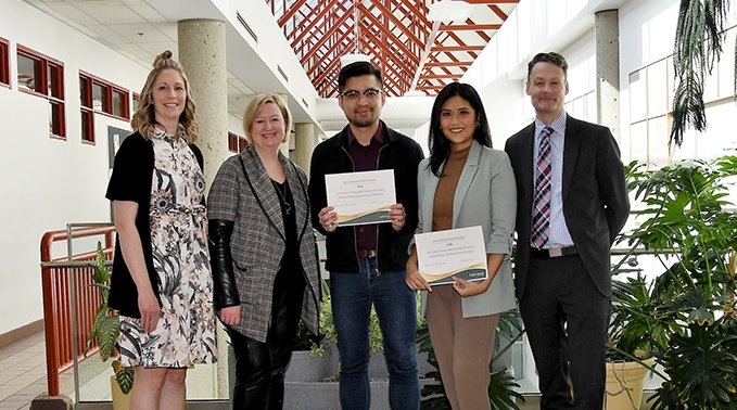 Raisa Tabusalla and Myles Nubla hold their first place Finding the U in Business Pitch Series certificates with School of Business instructors.