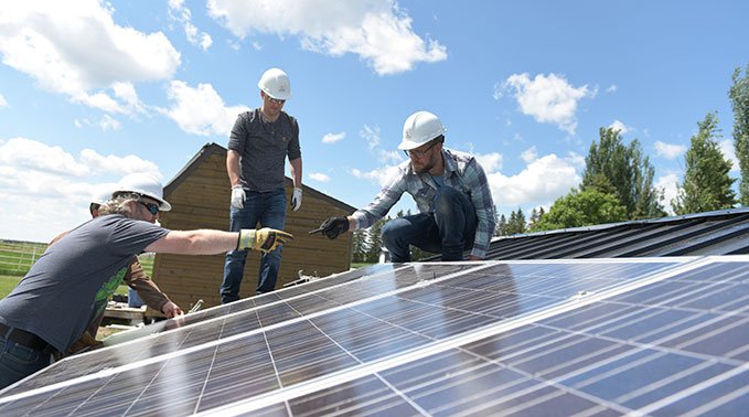 Students in the sustainable energy technology install solar panels during the onsite portion of thier program.