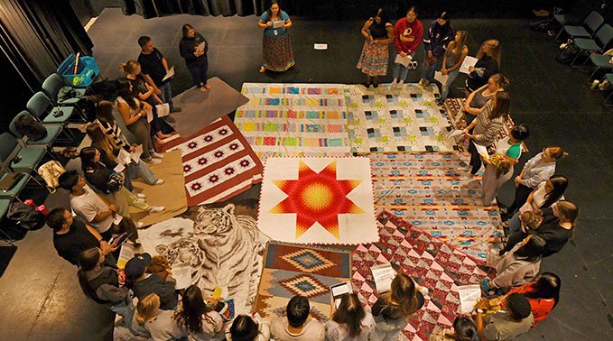A group of Lakeland College students and staff participate in a blanket ceremony.
