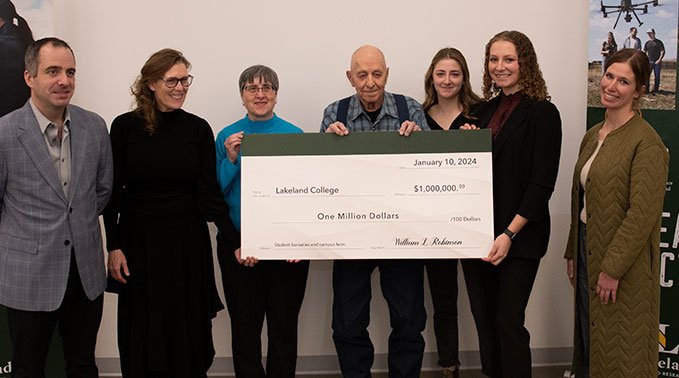 Bill Robinson with family and Lakeland College representatives presents a one million dollar cheque.