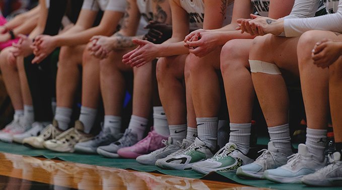 A close up of the hands and feet of the Lakeland Rustlers women's basketball team.
