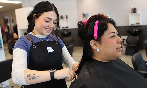 Student doing client's hair in salon