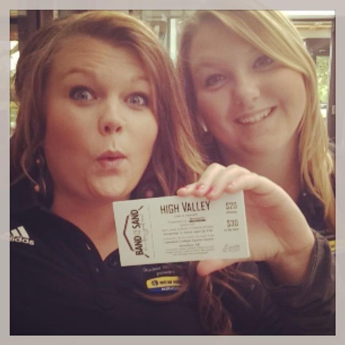 Two students hold the first ever Band in the Sand ticket.