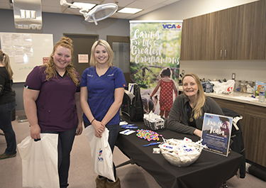 2 students talk to VCA rep at job fair