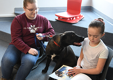 reading buddy dog with student