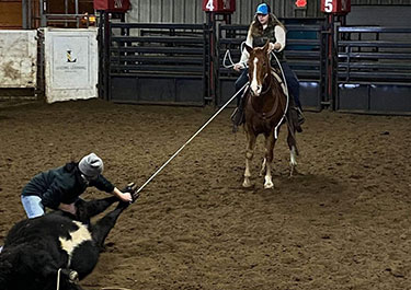 Juleianna Dunbar works with a classmate in a ranch horse skill lab.