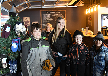 Emma Robb, one of the student organizers of the event, with three young shoppers.