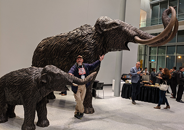 Hank Holowaychuk poses with woolly mammoth statues.
