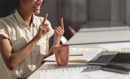 woman signing in front of a laptop