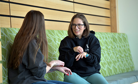 Two students practicing American Sign Language (ASL)
