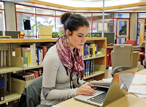 Student working on her laptop in the library