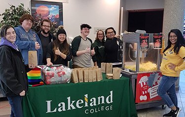Yap helping to serve popcorn at the students' association pride event