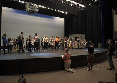 Kathryn Edwards (right-centre) and the production crew talk with the Wizard of Oz cast.