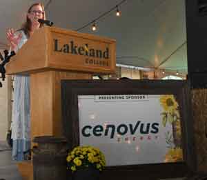 Alice speaking from podium with presenting sign Cenovus in front