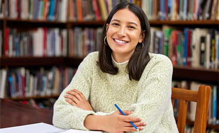 Student smiling in a library