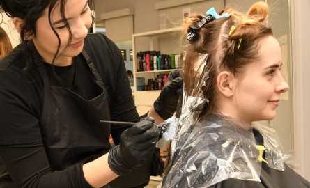 student stylist colouring client's hair