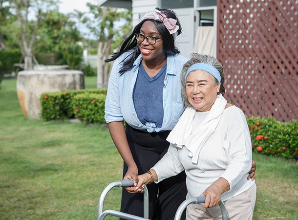 Community support practitioner with client using a walker