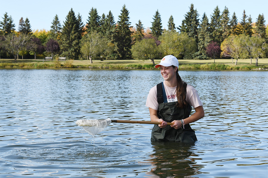 Environmental student smiling while working in a lake