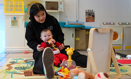 Student holding a child in the classroom