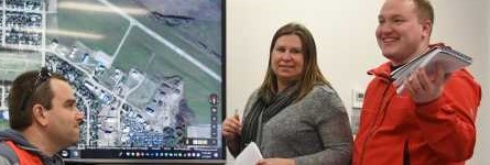 3 people around a municpal map