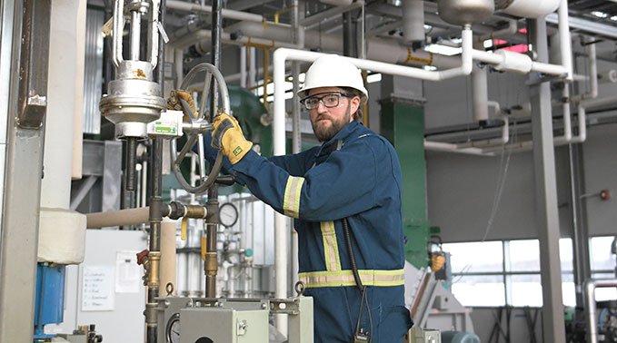 Krystoffer Cryderman holds a valve in the Energy Centre.