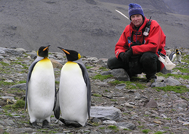 Photo: Distinguished Lakeland College alumnus, Brian Keating, observes two penguins in Antarctica.