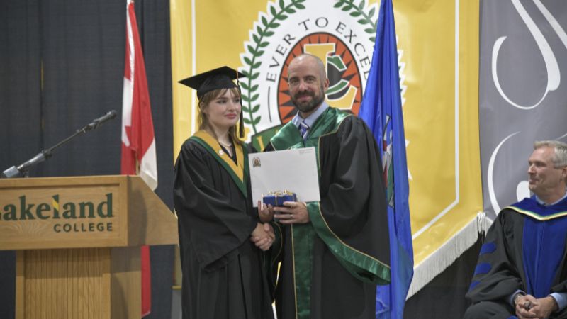 Hazel Flesher accepts the Vermilion campus' Governor General Medal from Adam Waterman, chair of Lakeland Board of Governors.