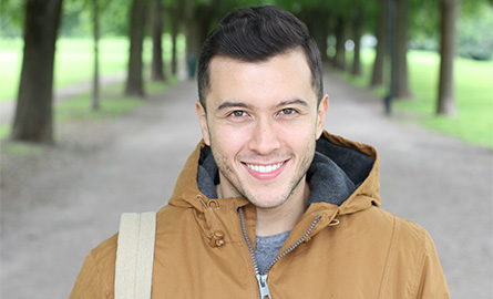 Student outside smiling on the way to class