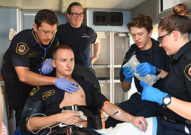 Carter listens to heart beat during field training