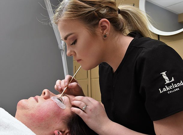 Student detailing a client's eyebrows