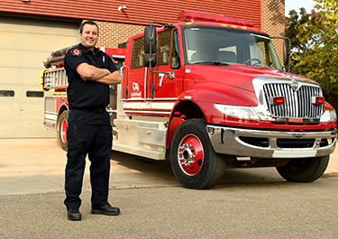 Lakeland grad outside the ETC next to a firetruck