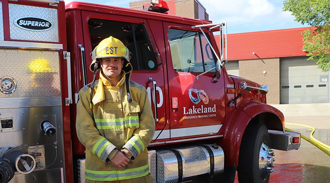 Noah Kirchgessner poses in front of a Lakeland College fire truck