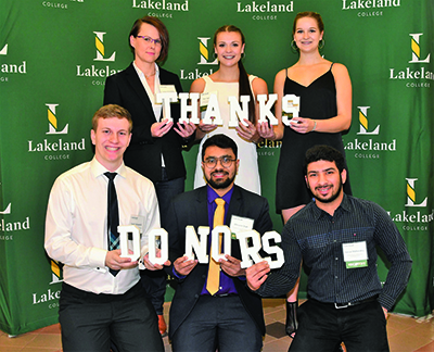 Lakeland College student award winners hold large letters that spell thanks donors