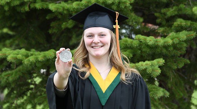 Maxine Lebo with her medal in cap and gown