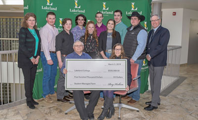 Roy Kubica (front row, left) presents Dr. Alice Wainwright-Stewart, president and CEO of Lakeland College (front row, right), with a donation to help grow Lakeland's Vermilion campus land base. Joining them for the presentation are Josie Van Lent, dean of Lakeland’s School of Agricultural Sciences (back row, far left), Scott Webb, chair of Lakeland's board of  governors (back row, far right), and representatives from Lakeland's SMF and the Vermilion Campus Students' Association