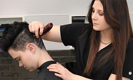 Student working on client, giving a hair tattoo