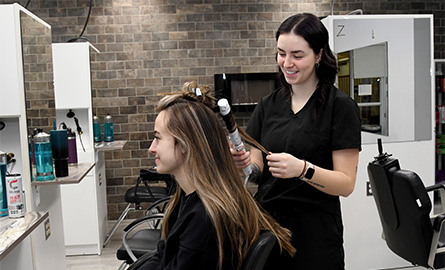 Student curling a client's hair