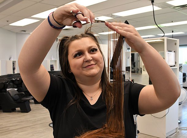 Student cutting hair with scissors