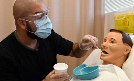 health care aide feeds synthetic patient