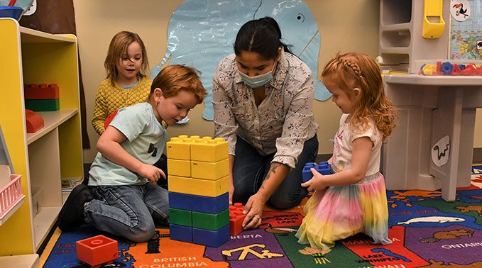 A group of children play with building blocks during the student-led play program.
