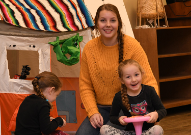 A student in the infant room with one of the children