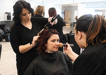 student curls model's hair